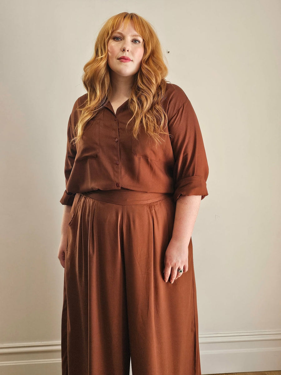 Woman wearing a brown outfit against a plain background